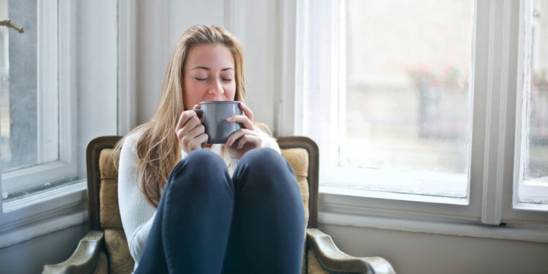 Woman enjoying hot beverage in comfort of her house