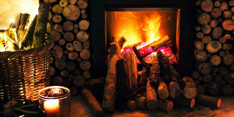 A fireplace in a home surrounded by logs