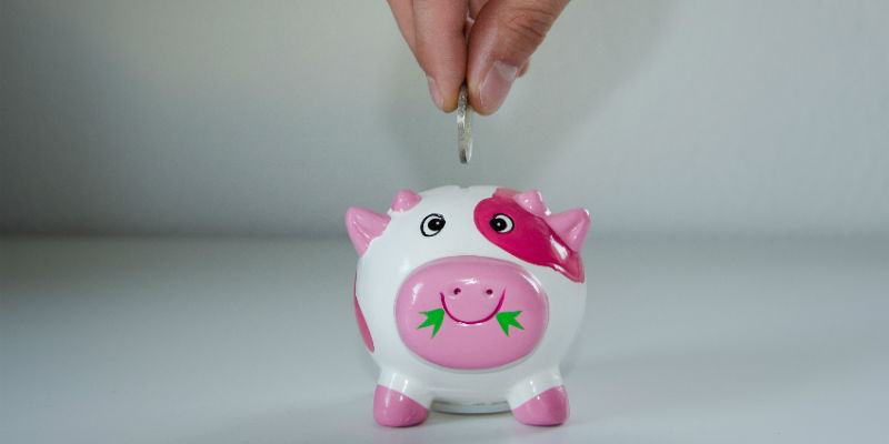 Person putting money into a piggy bank